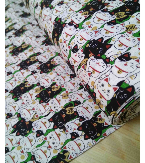 Tela japonesa. Dobby Maneki nekos sobre verde.