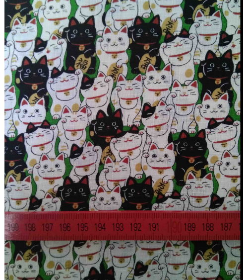 Tela japonesa. Dobby Maneki nekos sobre verde.