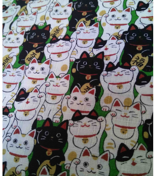 Tela japonesa. Dobby Maneki nekos sobre verde.