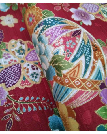 Satin fabric with temari over carmine red background