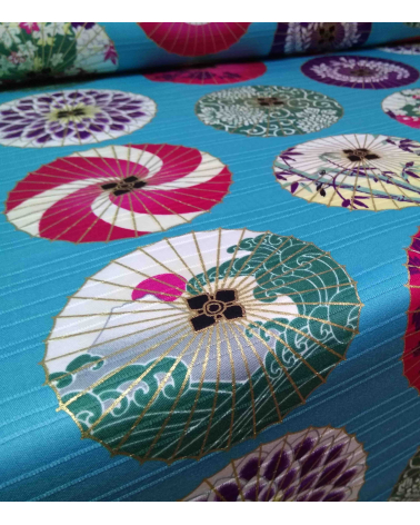 Cotton satin fabric. Paper umbrellas over turquoise-blue background.
