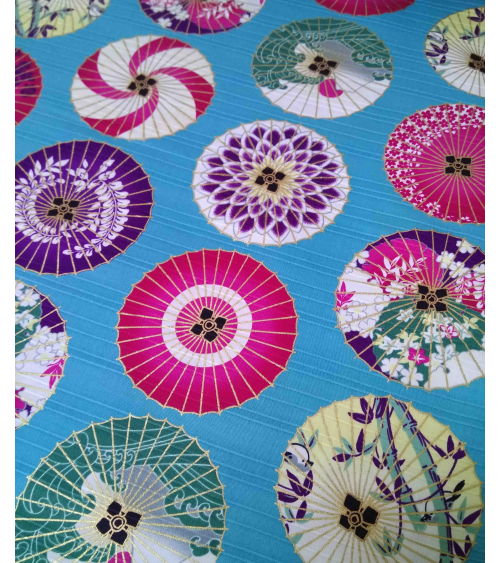 Cotton satin fabric. Paper umbrellas over turquoise-blue background.