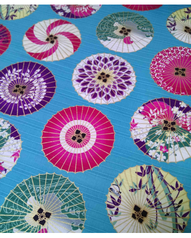 Cotton satin fabric. Paper umbrellas over turquoise-blue background.