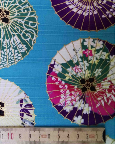 Cotton satin fabric. Paper umbrellas over turquoise-blue background.