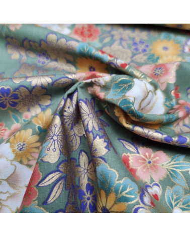 Japanese fabric with multicolor and golden flowers on green.
