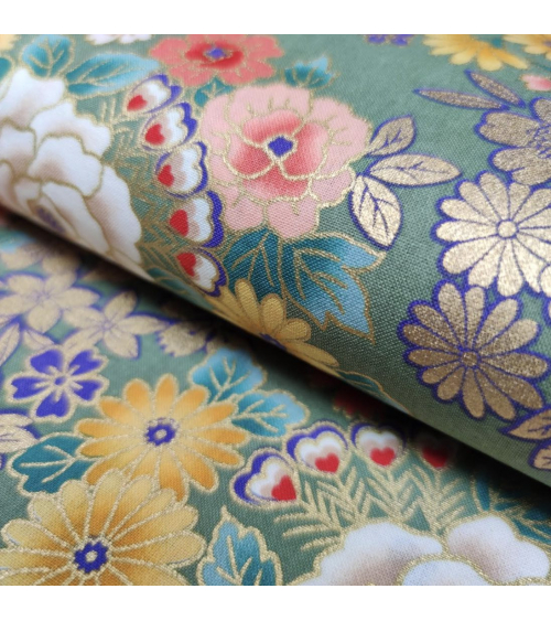 Japanese fabric with multicolor and golden flowers on green.