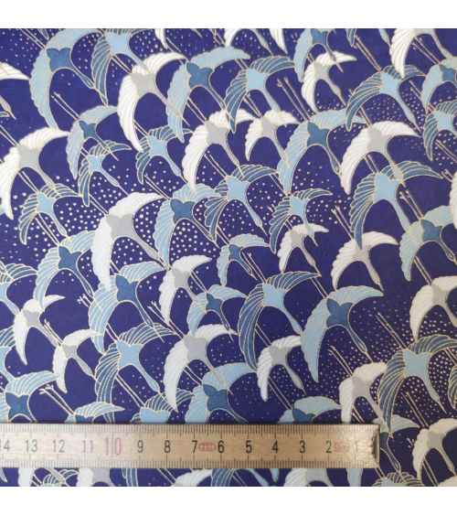 Papel japonés Chiyogami con grullas al vuelo sobre fondo azul.