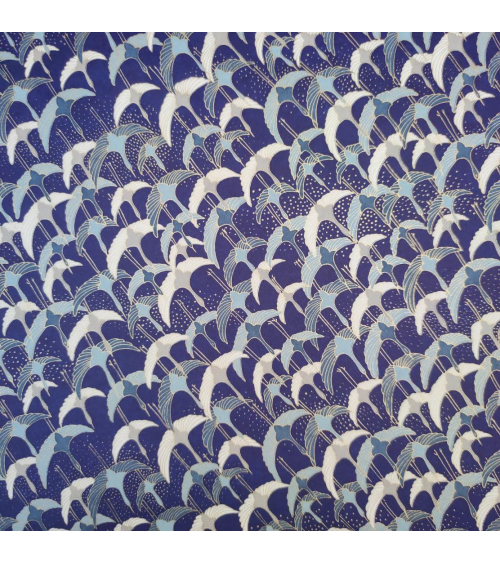 Papel japonés Chiyogami con grullas al vuelo sobre fondo azul.