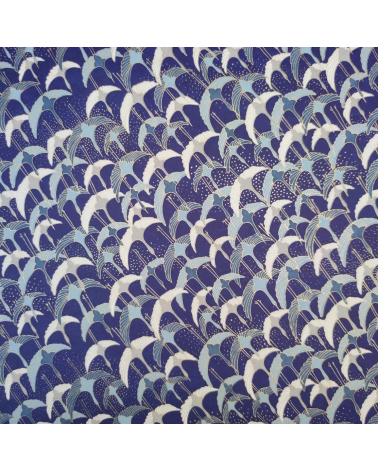 Papel japonés Chiyogami con grullas al vuelo sobre fondo azul.