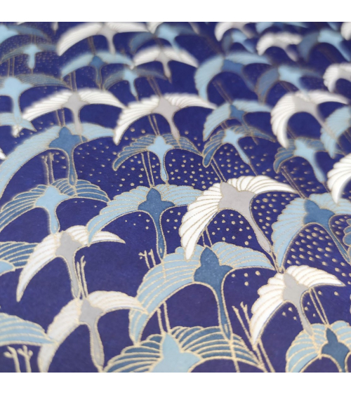 Papel japonés Chiyogami con grullas al vuelo sobre fondo azul.