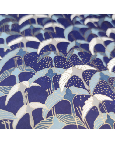 Papel japonés Chiyogami con grullas al vuelo sobre fondo azul.