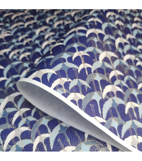 Papel japonés Chiyogami con grullas al vuelo sobre fondo azul.