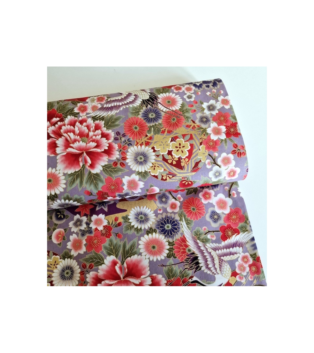 Japanese fabric. Multicolored cranes (tsuru) and flowers (hana) over lilac background, outlined in gold.