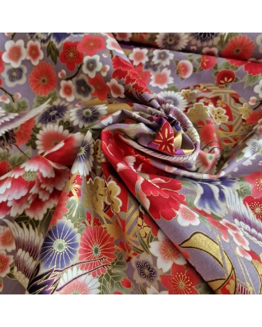 Japanese fabric. Multicolored cranes (tsuru) and flowers (hana) over lilac background, outlined in gold.