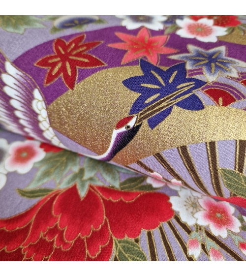 Japanese fabric. Multicolored cranes (tsuru) and flowers (hana) over lilac background, outlined in gold.