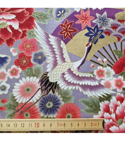 Japanese fabric. Multicolored cranes (tsuru) and flowers (hana) over lilac background, outlined in gold.