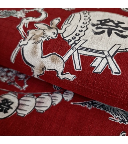 Tela japonesa "Choju-giga" con fondo rojo guinda, en dobby de algodón 100%.