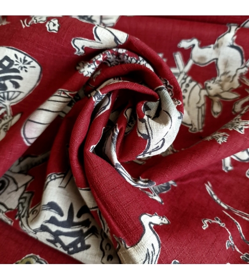 Tela japonesa "Choju-giga" con fondo rojo guinda, en dobby de algodón 100%.
