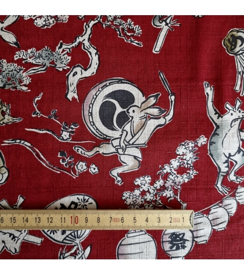 Tela japonesa "Choju-giga" con fondo rojo guinda, en dobby de algodón 100%.