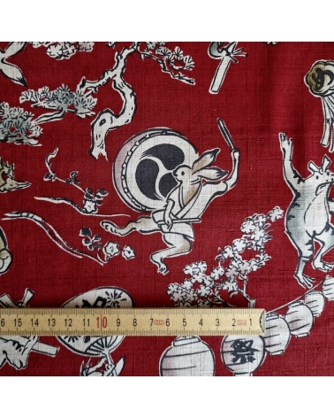 Tela japonesa "Choju-giga" con fondo rojo guinda, en dobby de algodón 100%.