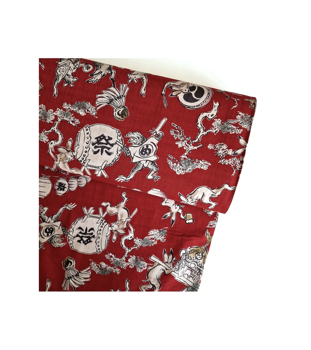 Tela japonesa "Choju-giga" con fondo rojo guinda, en dobby de algodón 100%.