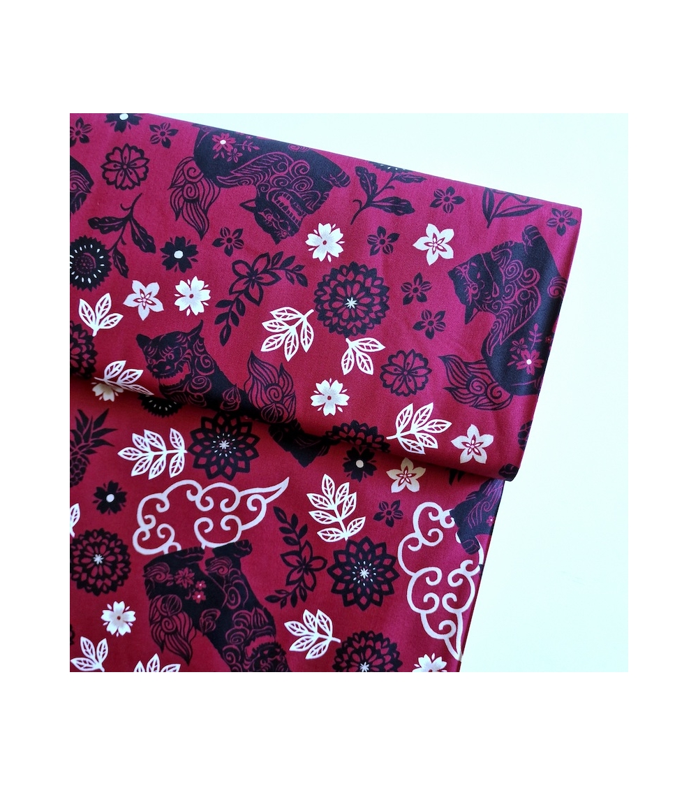 Japanese fabric. Okinawa Shisa katagami bourdeaux background.