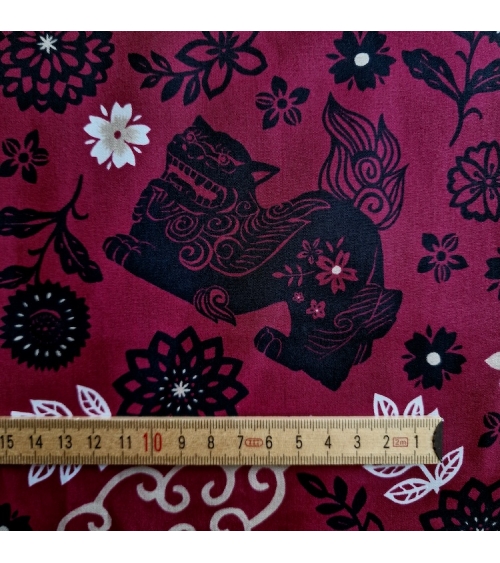 Japanese fabric. Okinawa Shisa katagami bourdeaux background.