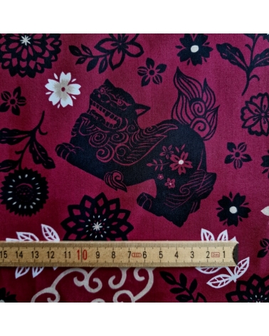 Japanese fabric. Okinawa Shisa katagami bourdeaux background.