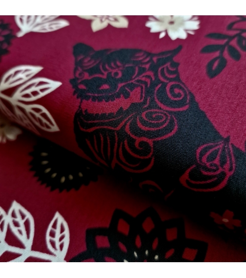 Japanese fabric. Okinawa Shisa katagami bourdeaux background.