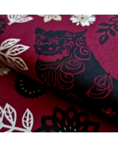 Tela japonesa. Okinawa Shisa katagami fondo burdeos.